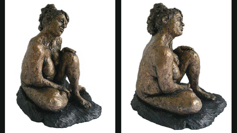 Small clay figure of Gwen seated with her left knee raised.